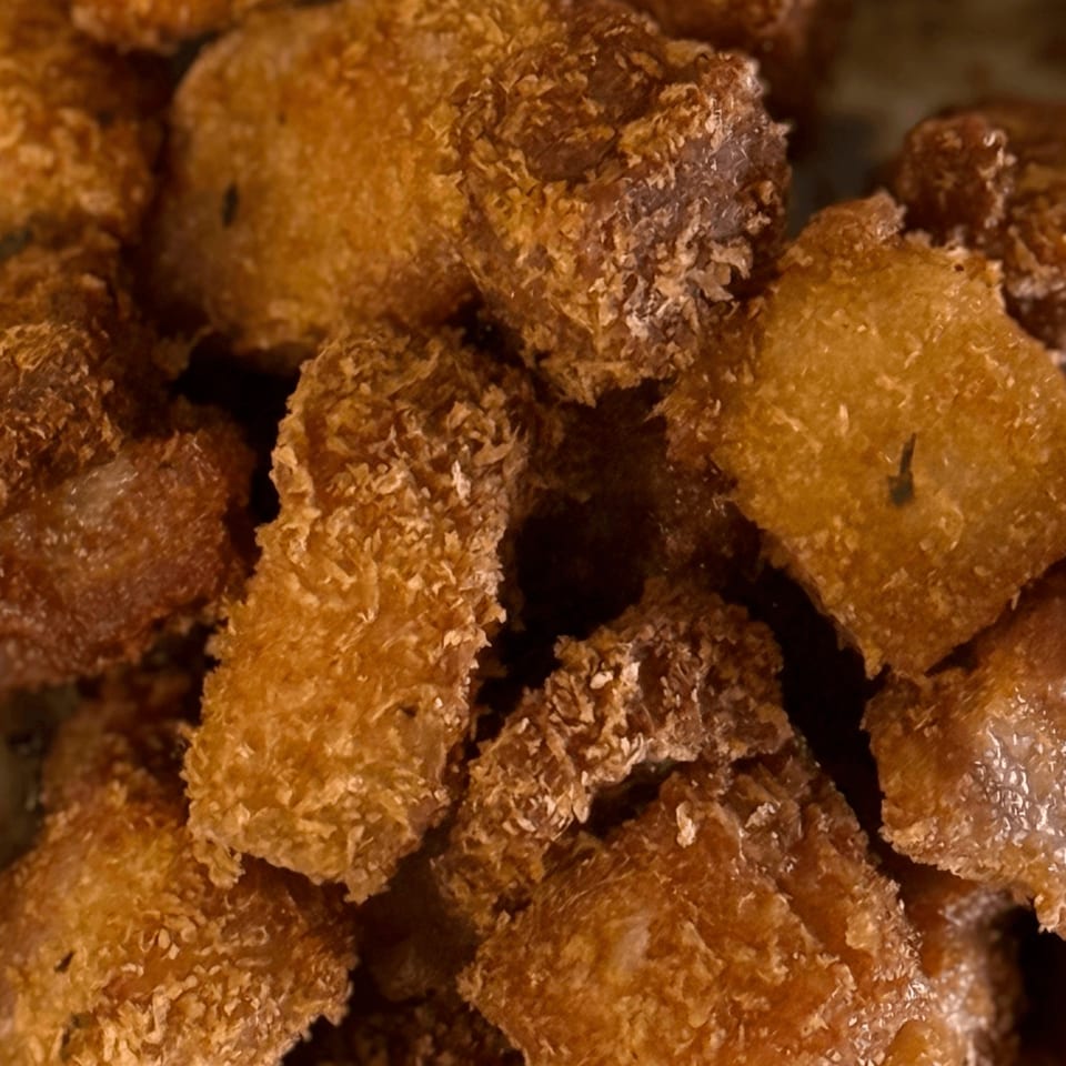 Close-up of crispy, golden-brown fried food pieces, possibly chicken or fish, from Da Kane's Kitchen.