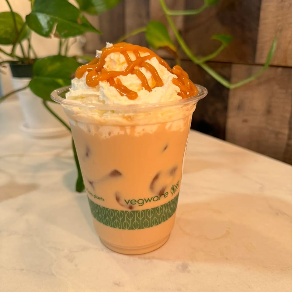 Iced caramel coffee with whipped cream and caramel drizzle in a clear cup from Da Kane's Kitchen.